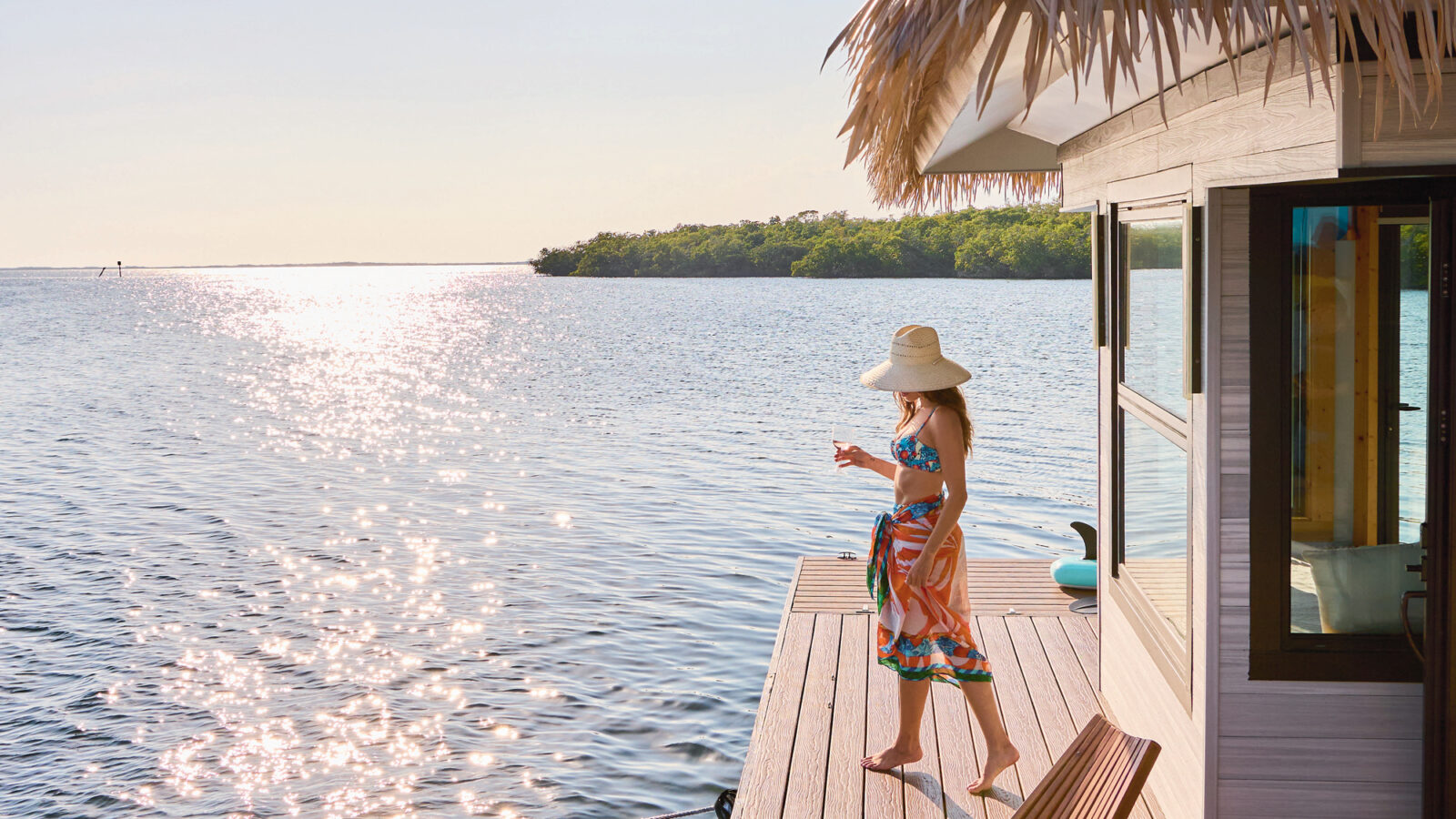 A woman stands on a floating dock on the water
