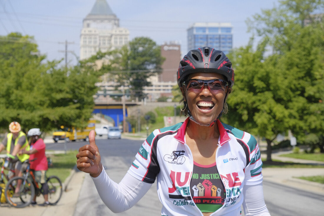 A woman smiling while wearing cycling gear