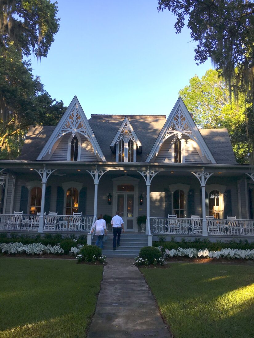 People walk up the steps of a victorian cottage