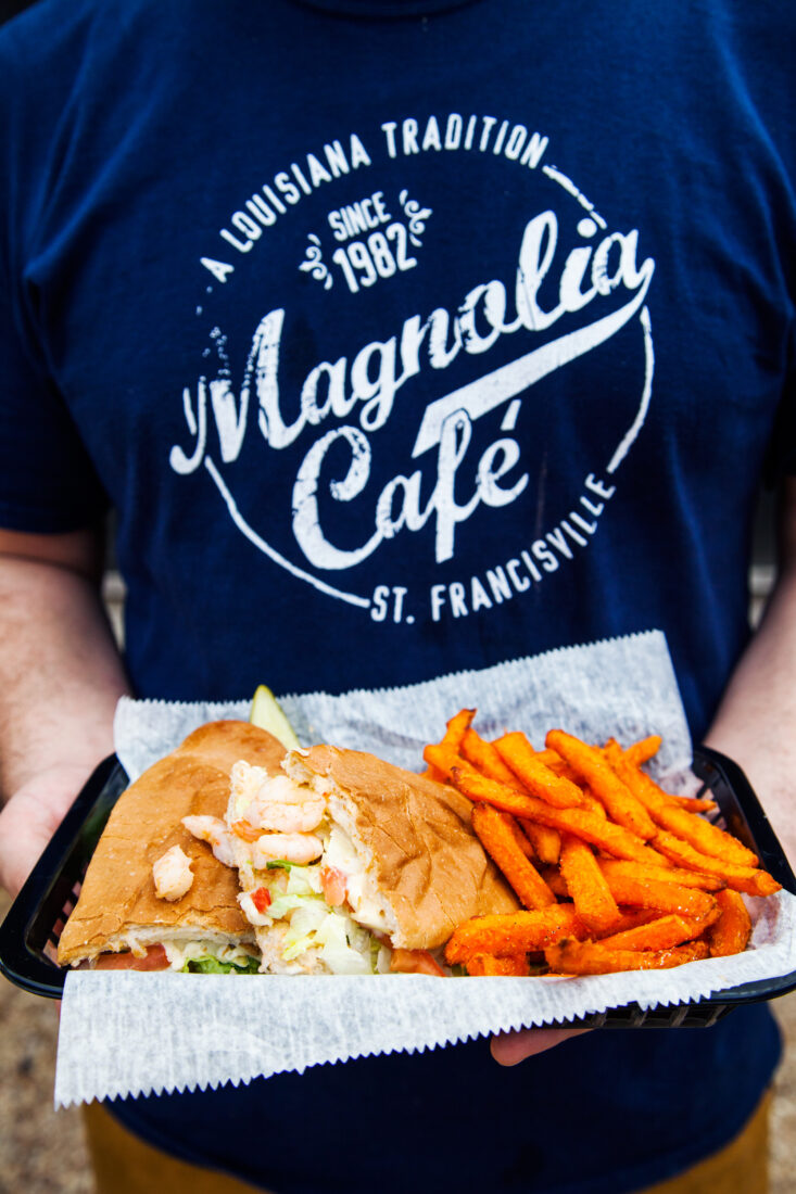 A person holds a black basket of lunch
