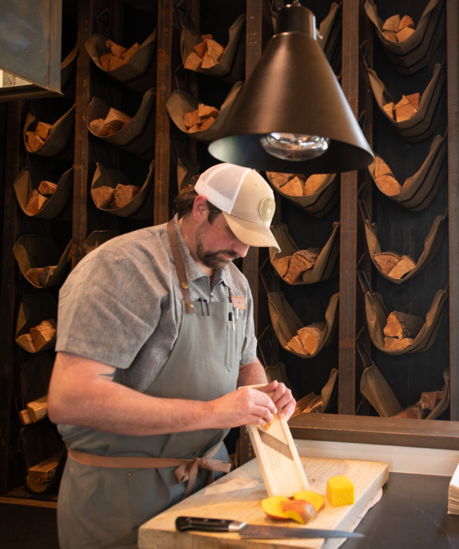 A man slices fruit in a kitchen