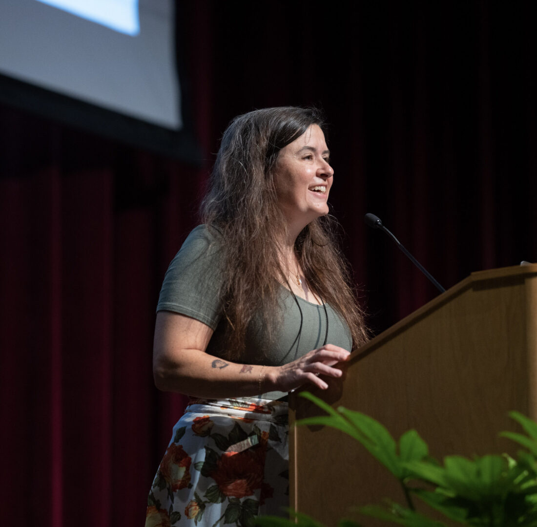 A woman stands at a podium
