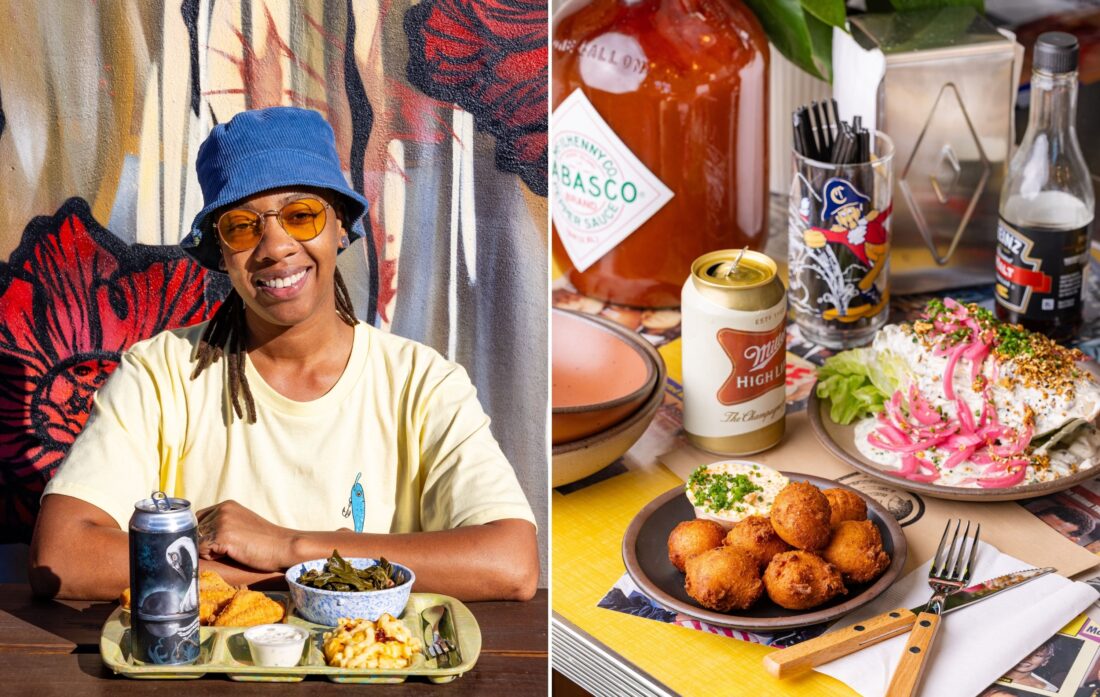 A woman smiles by a tray of fried fish; plates of hush puppies and a salad