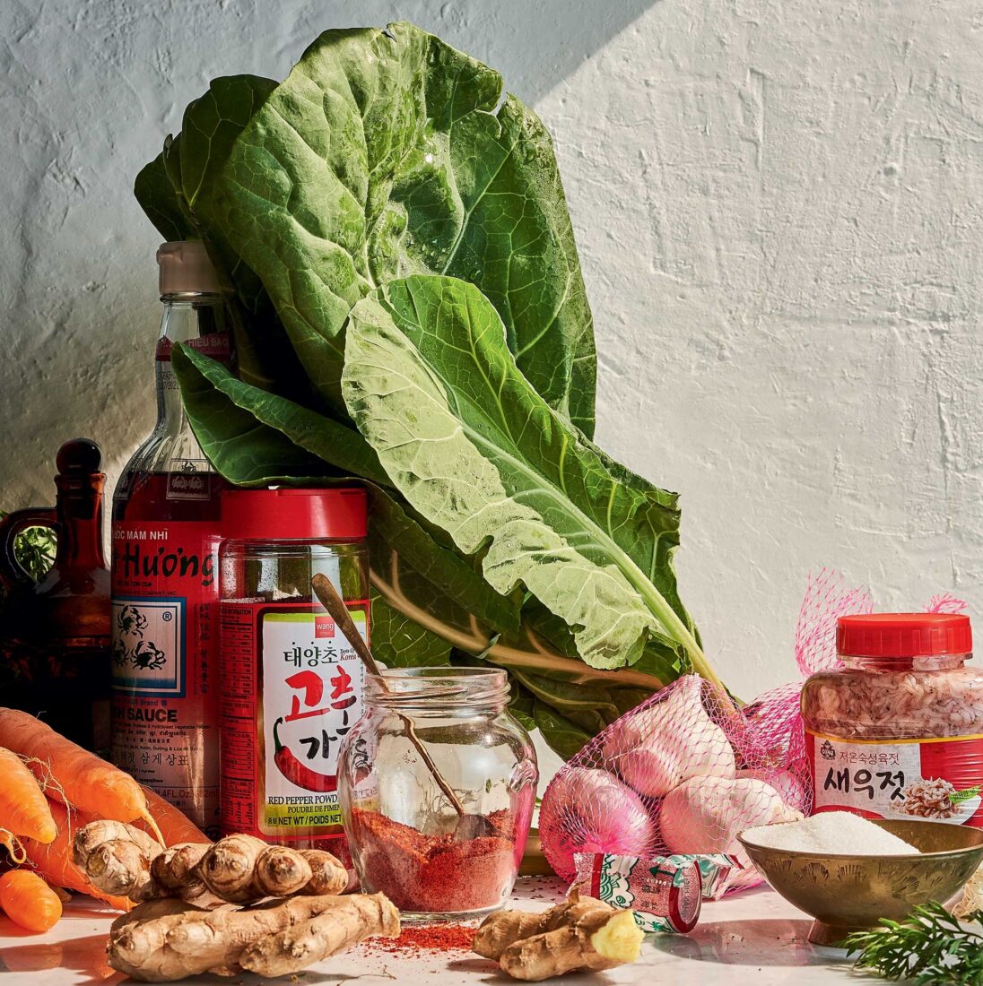collard greens and kimchi ingredients including gochugaru, carrots and ginger