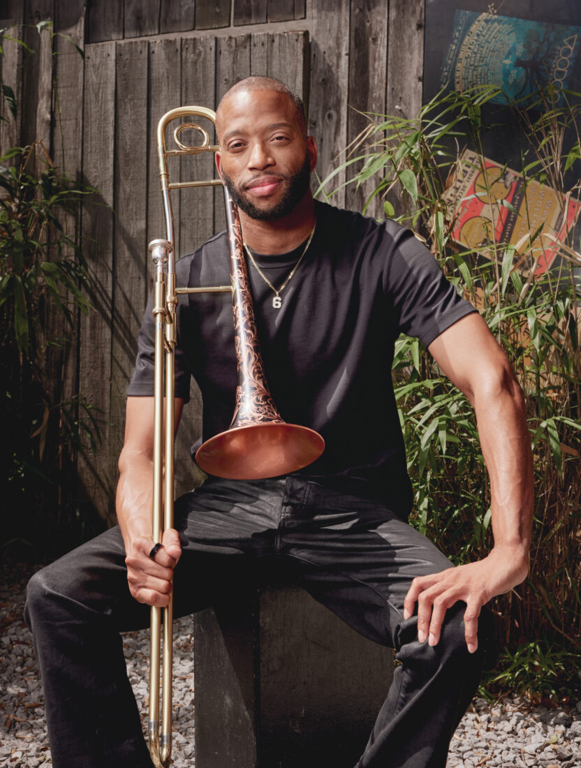 A portrait of a man sitting outside with a trombone