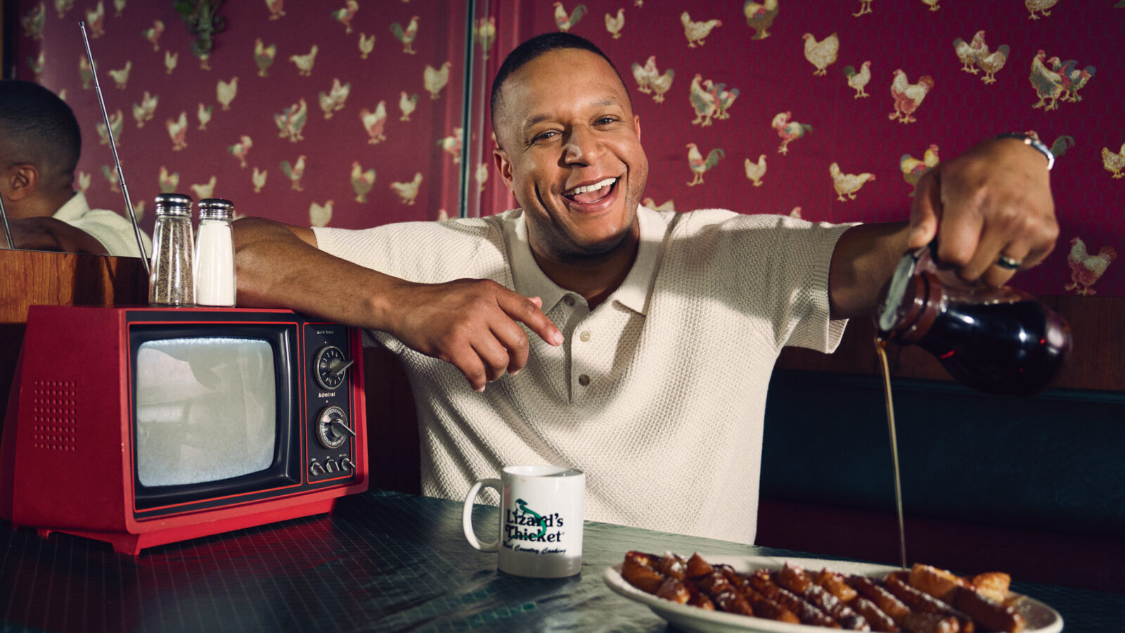 Craig Melvin pours syrup over french toast in a restaurant