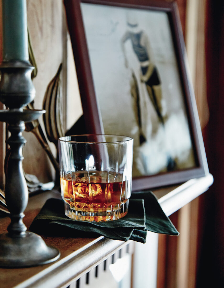 A glass of bourbon on a shelf