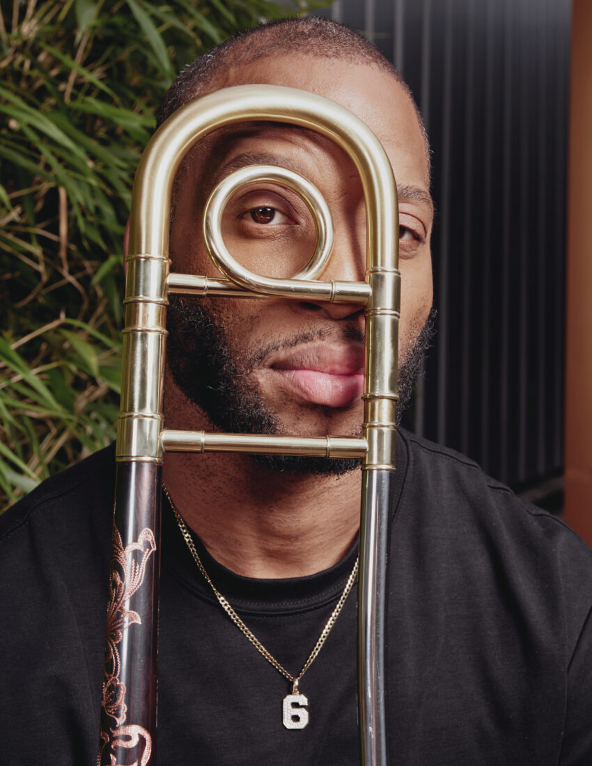 A portrait of a man with a brass instrument in front of his face