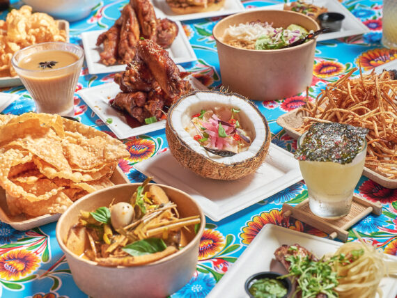 Coconut escolar ceviche, caramel fish sauce wings, and taro fries on a table