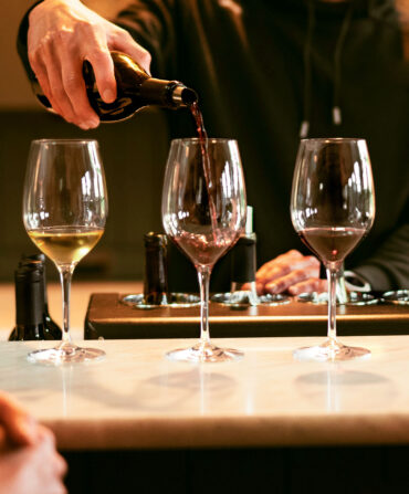 three wines with one being poured in to in the center
