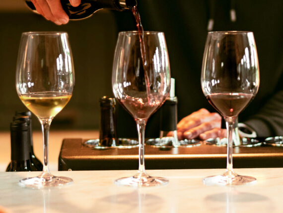 three wines with one being poured in to in the center