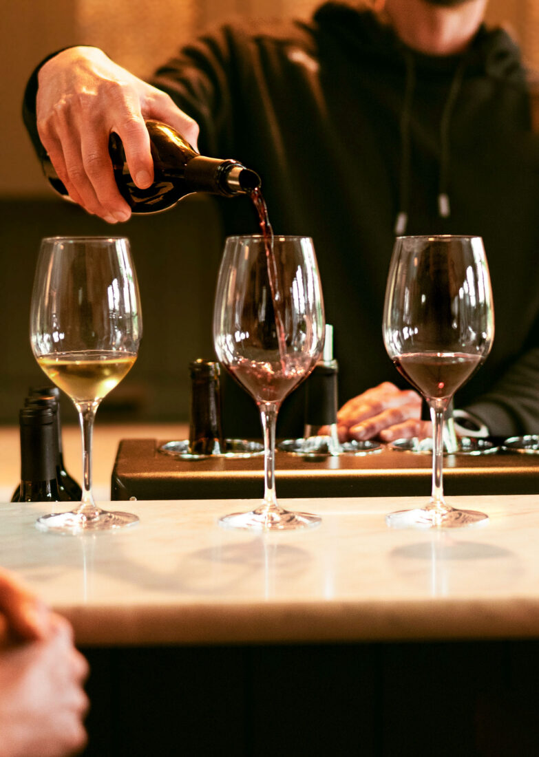 three wines with one being poured in to in the center