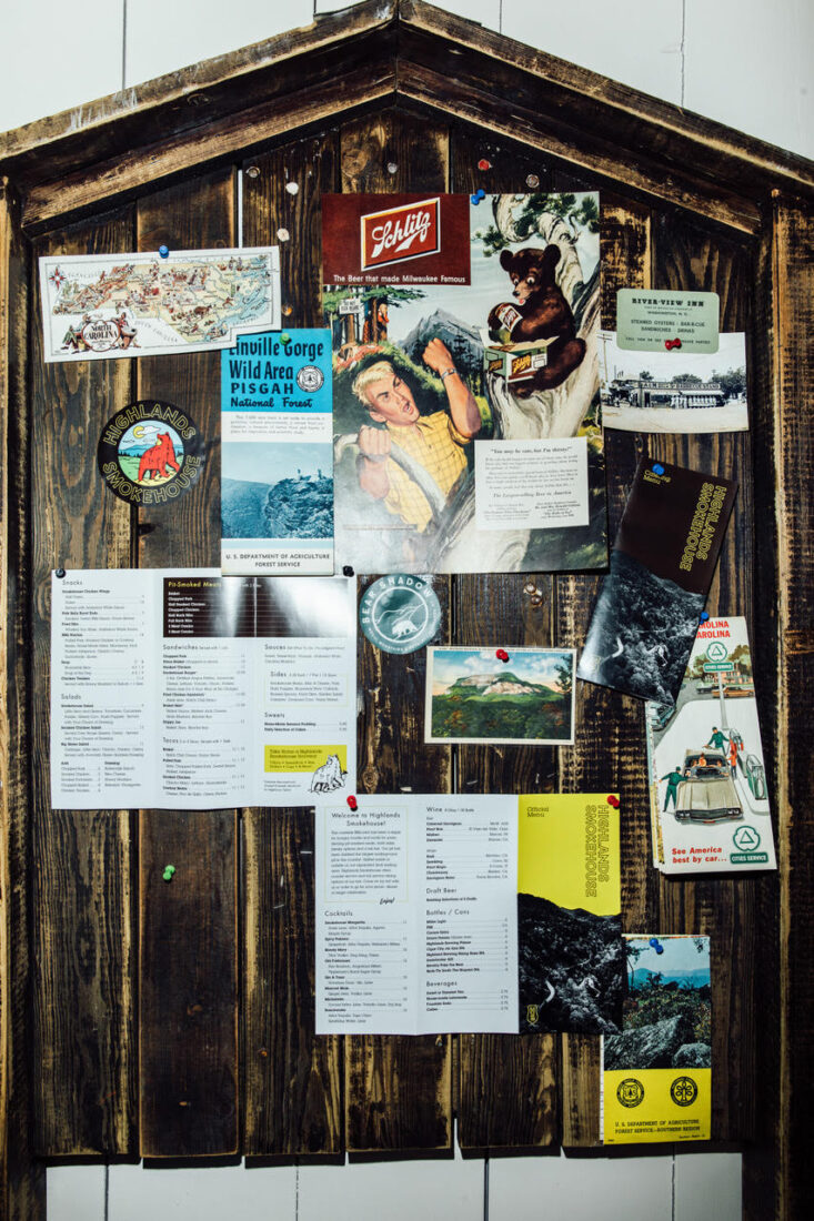a wooden board at Highlands Smokehouse with menus, local stickers and brochures