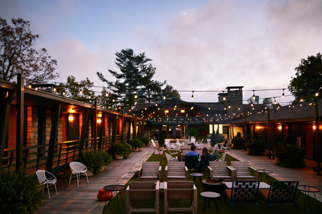 a couple sits on the Skyline Lodge patio at dusk