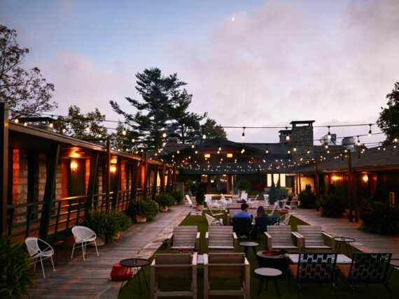 a couple sits on the Skyline Lodge patio at dusk