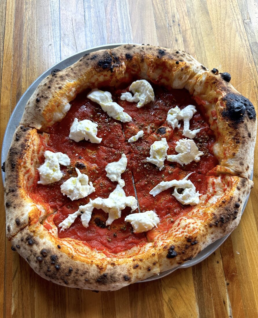 A red sauce pizza with torn mozzarella
