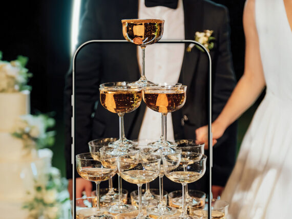 Champagne glasses in front of a bride and groom