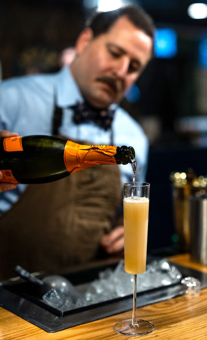 A man pours sparkling wine into a glass