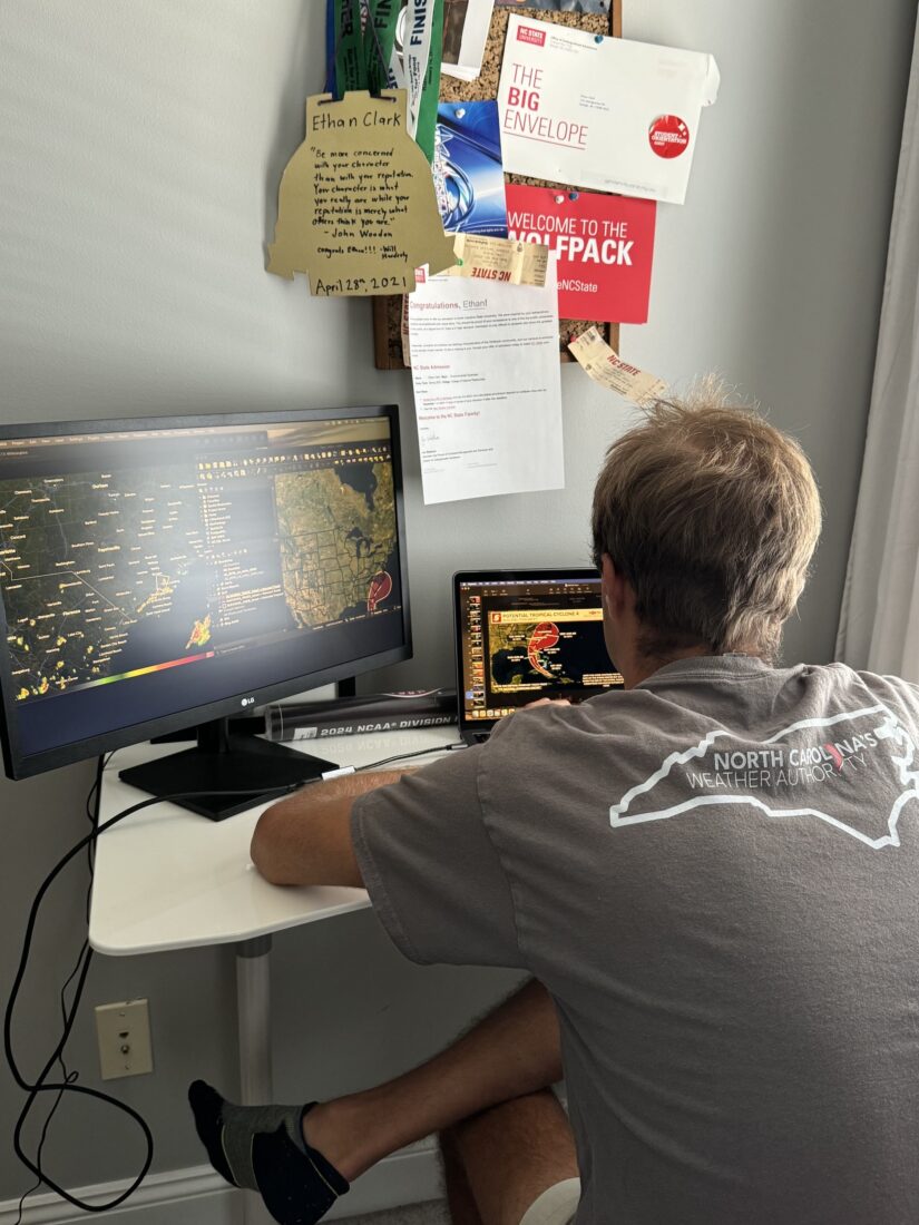 A man sits at a computer desk