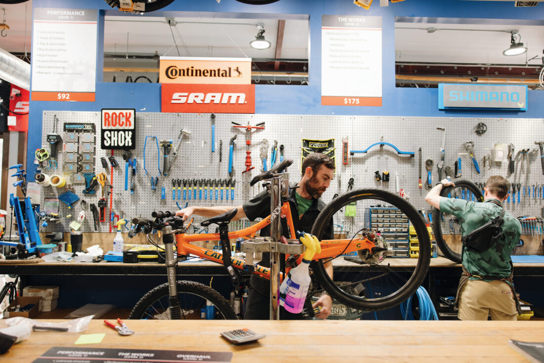 A man works behind a bike repair shop counter