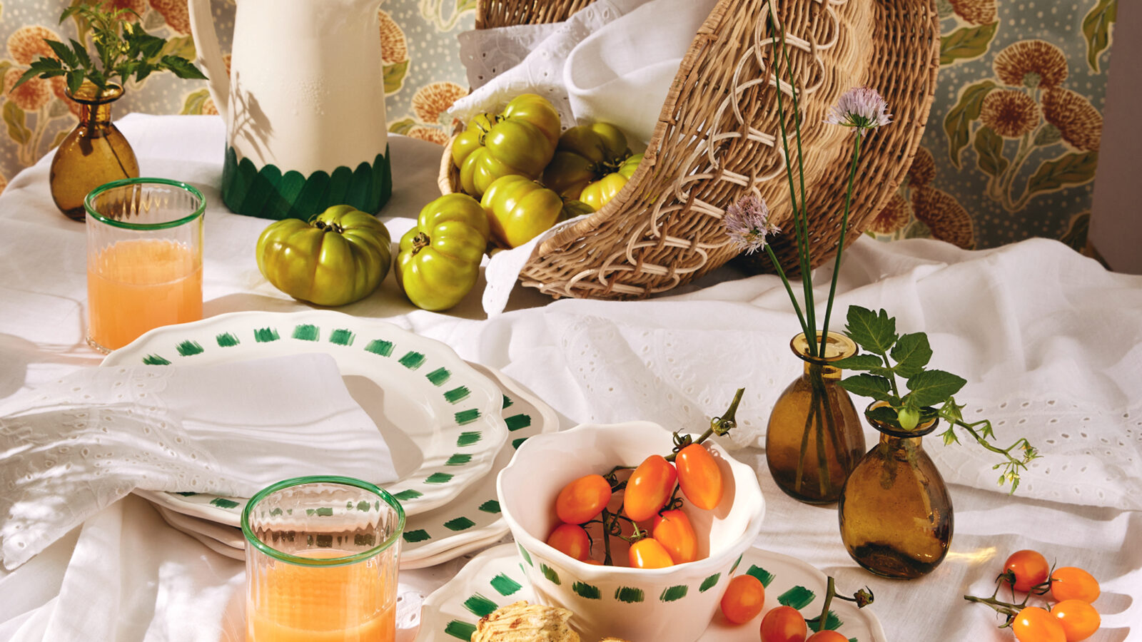 A spread of dinnerware plates and tomatoes on a table