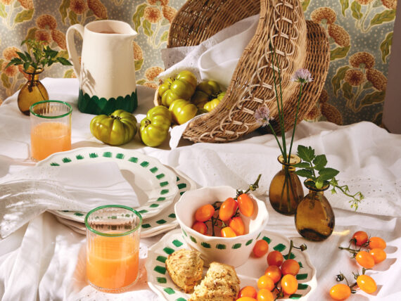 A spread of dinnerware plates and tomatoes on a table