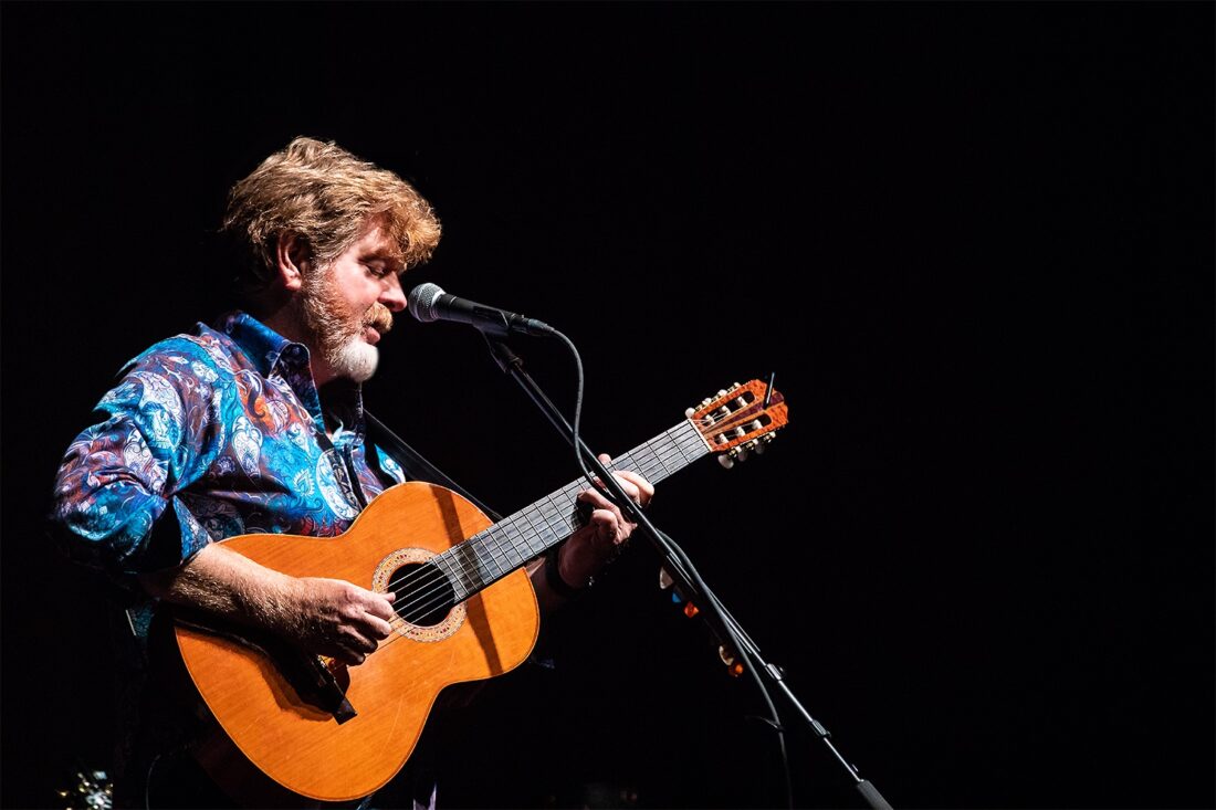 A man plays a guitar on stage