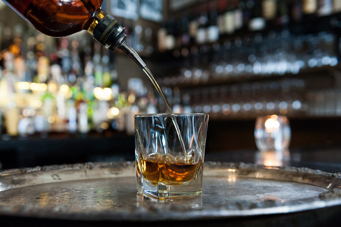 Bourbon being poured into a cocktail glass