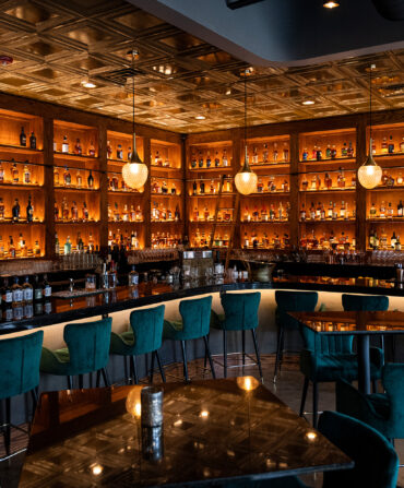 A view of a bar with bottles stacked on shelves