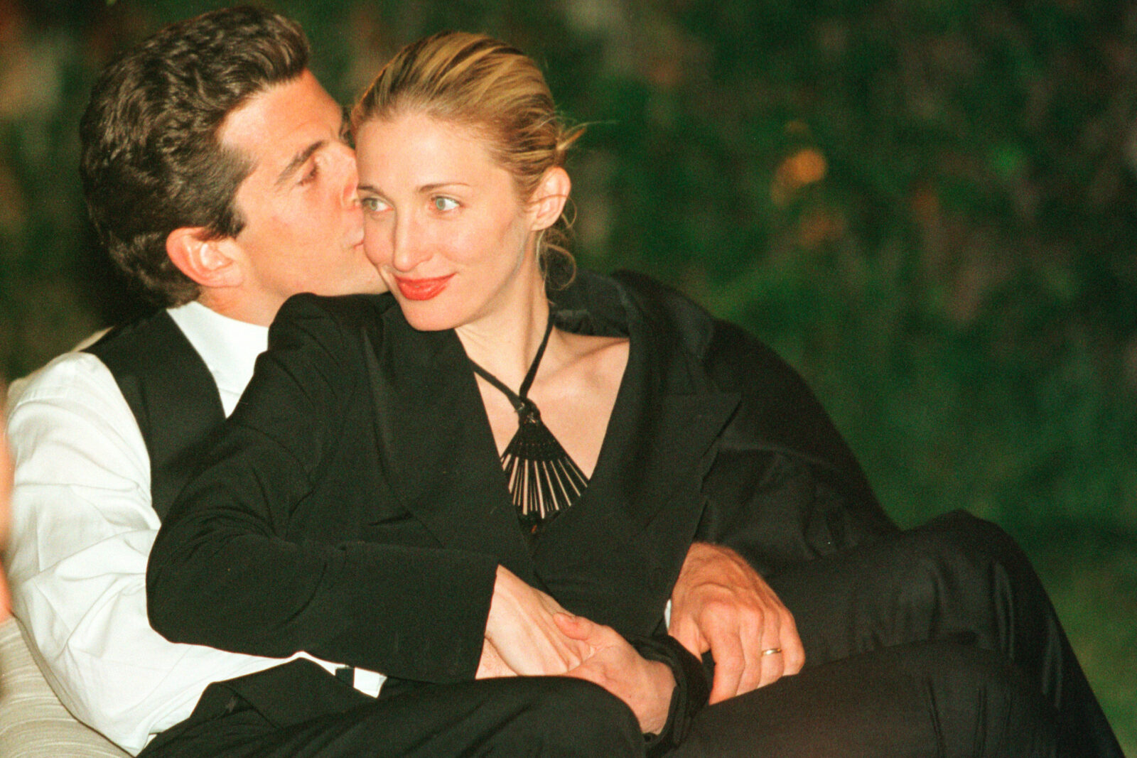 A woman sitting in a man's arms.