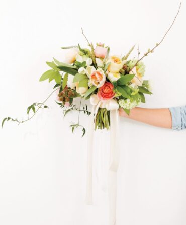 A hand holds a bouquet of flowers