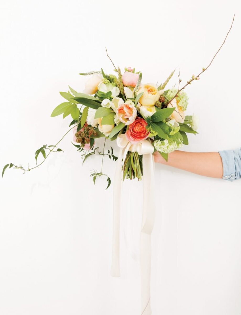 A hand holds a bouquet of flowers