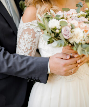 A bride and groom with a bouquet of flowers