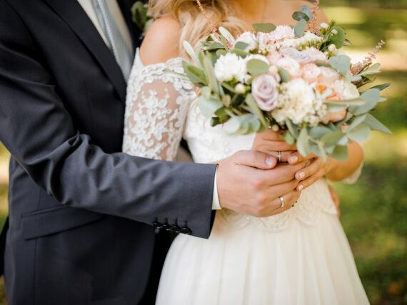A bride and groom with a bouquet of flowers