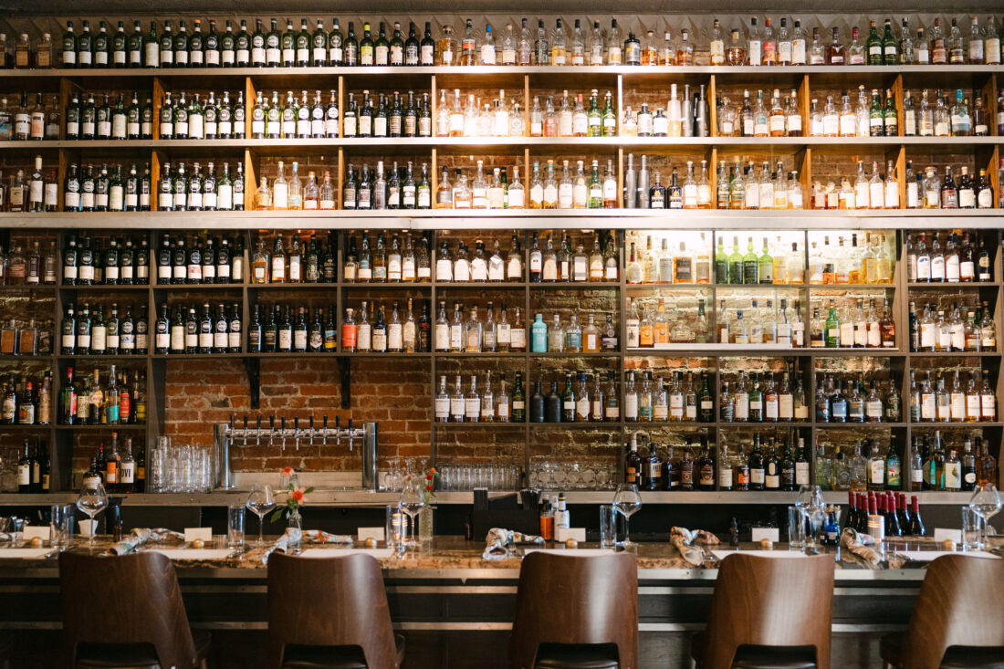 A floor-to-ceiling wall of whiskey in Jack Rose Dining Saloon’s dining room.