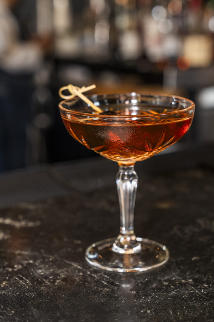 A preview of the Natchez Trace Cocktail, a blend of rye, bourbon whiskey, dry vermouth, amaro arancia, maraschino liqueur, and yellow chartreuse offered on the week-long Visit Sevierville special menu at The Garden & Gun Club. 