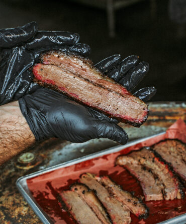 A hand holds sliced meat