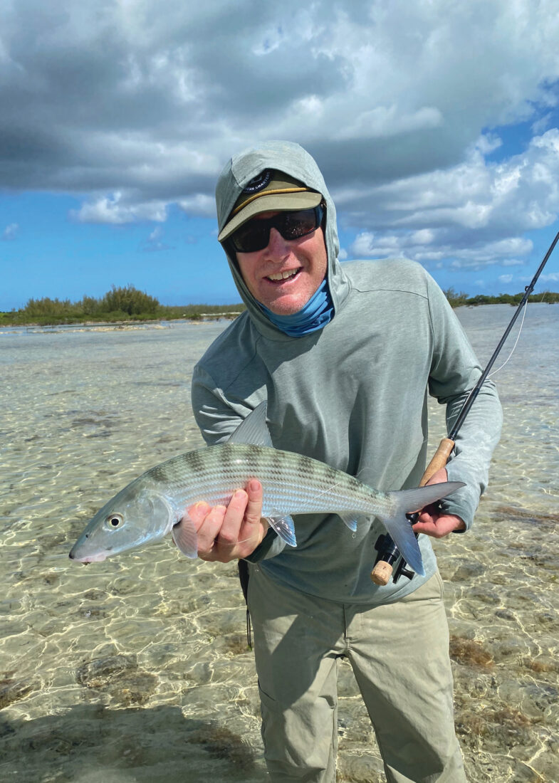A man holds a bonefish in water