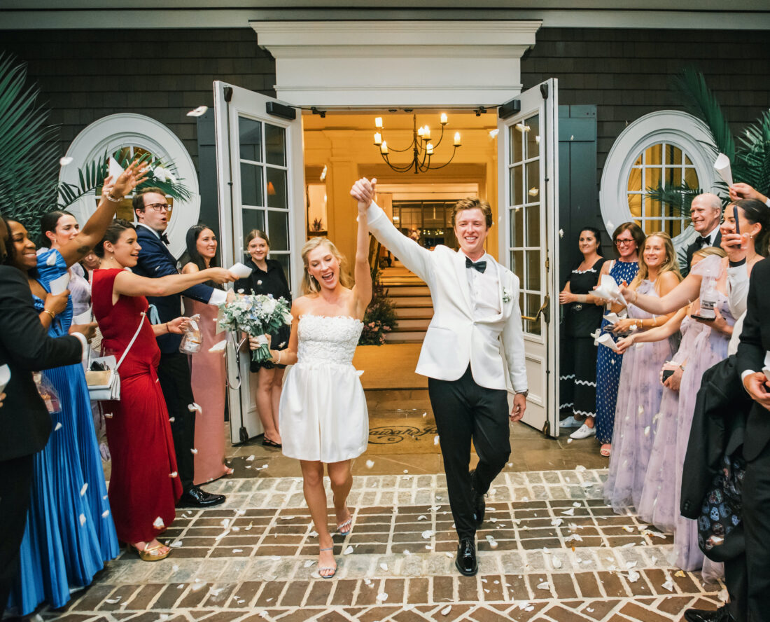 A married couple walks through a cheering crowd