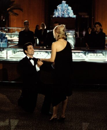 A movie still from Sweet Home Alabama of a man kneeling in a jewelry store to propose to a blonde woman