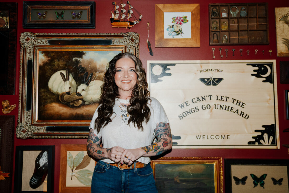 A portrait of a woman against a gallery wall