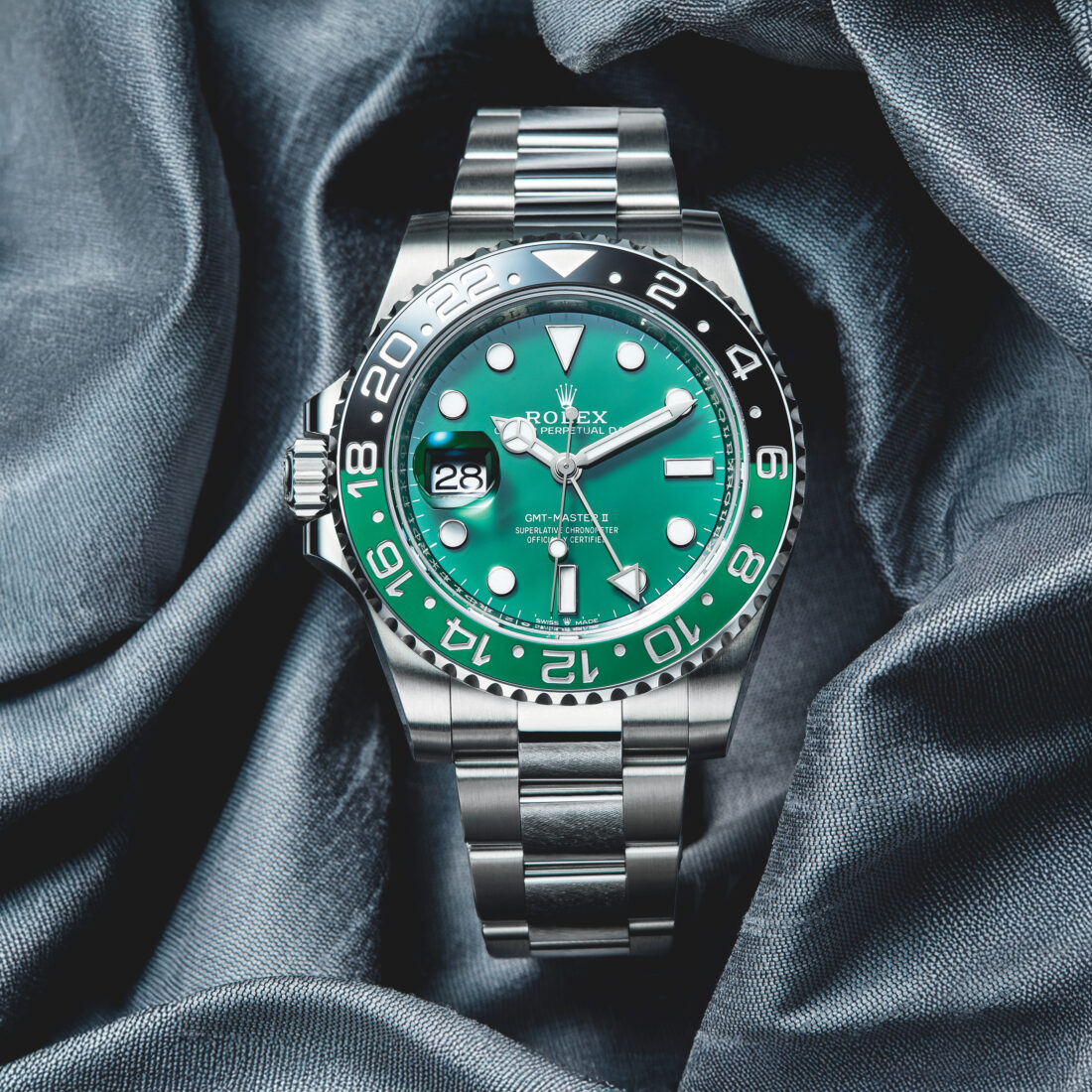 A watch with a jewel green face