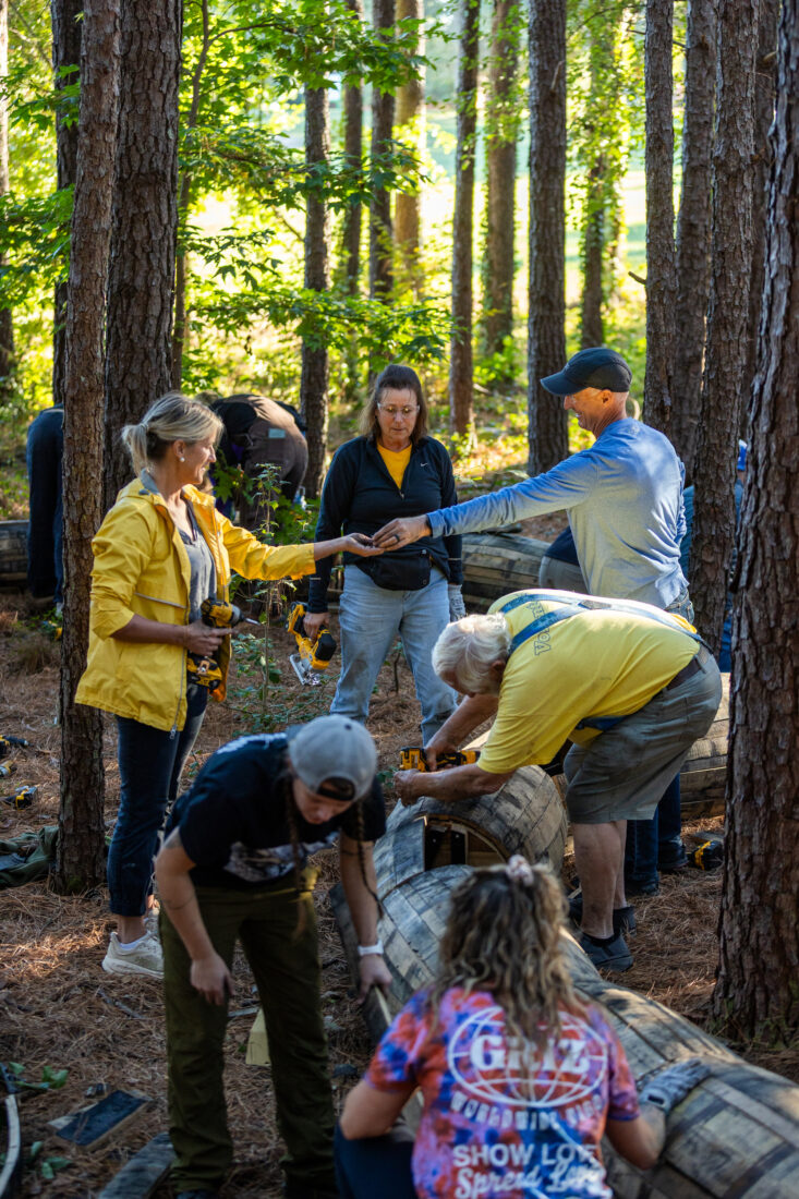 Volunteers build a wood sculpture in a park