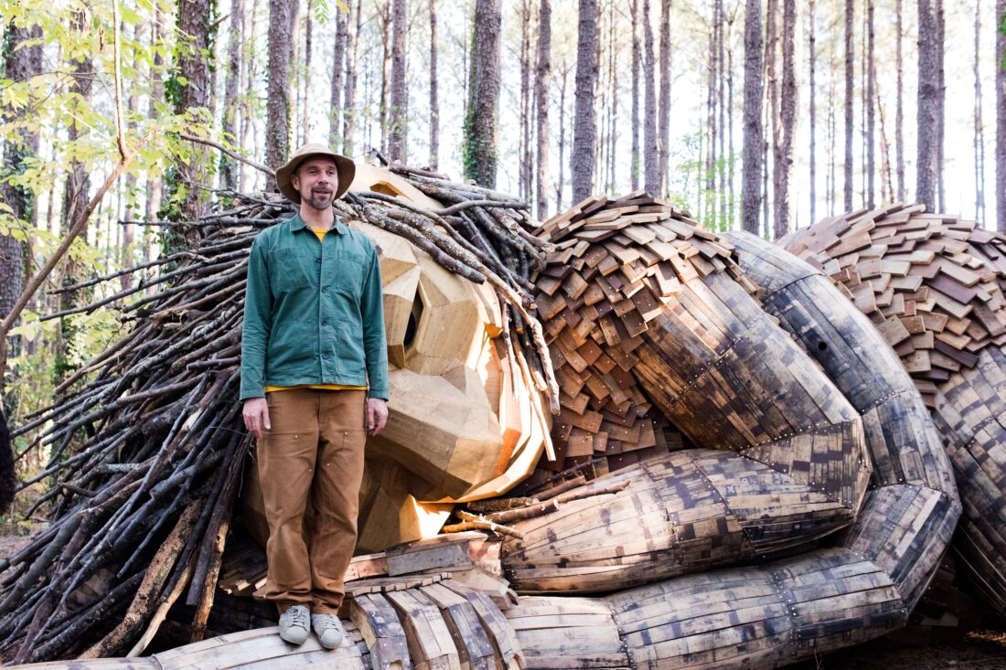 a man atop a wooden sculpture