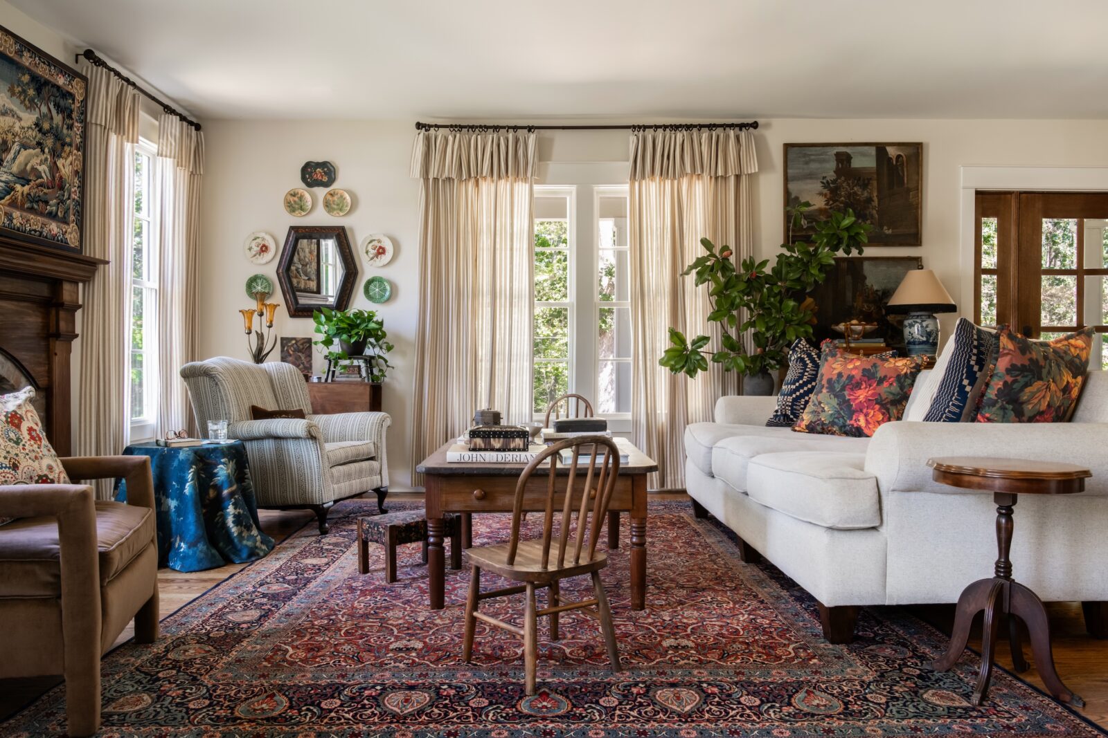 a living room with couch, Parisian tapestry, restored fireplace, and cabbage plates