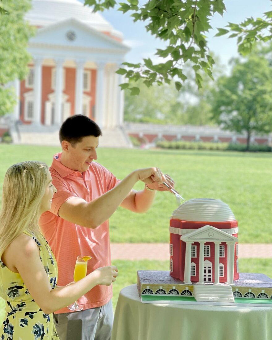 a couple cuts into a Rotunda-themed cake