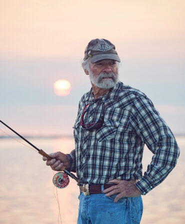 A portrait of a man with a fly rod