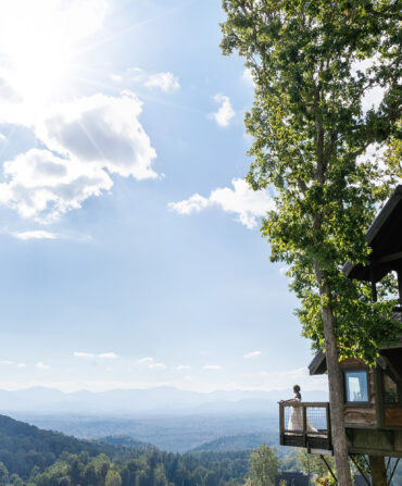 A bride on a deck overlooking a mountain scene