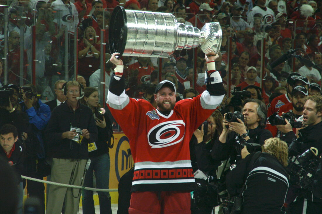 A man lifts a trophy into the air