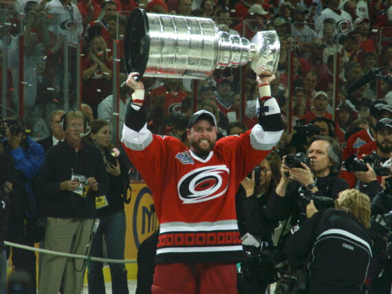 A man lifts a trophy into the air